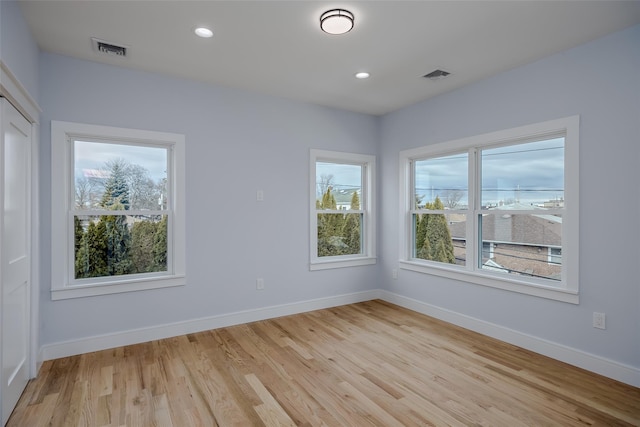 unfurnished room with light wood-style floors, recessed lighting, visible vents, and baseboards