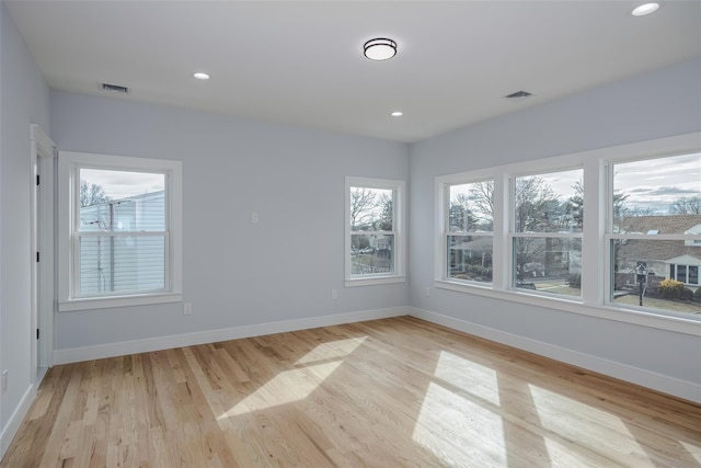 unfurnished room with light wood-style floors, visible vents, baseboards, and recessed lighting