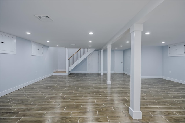 finished below grade area featuring visible vents, baseboards, wood tiled floor, stairs, and recessed lighting