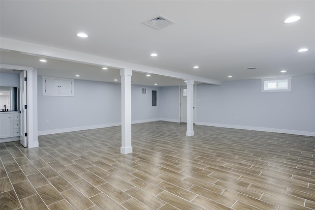 below grade area with baseboards, wood tiled floor, visible vents, and recessed lighting