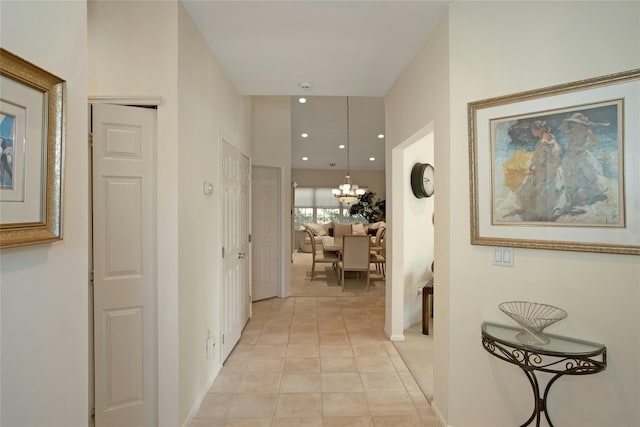 hallway featuring light tile patterned flooring and a notable chandelier