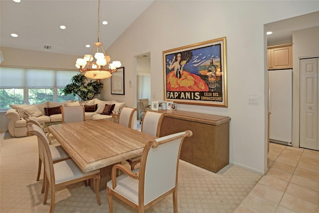 dining space with a notable chandelier, vaulted ceiling, and light tile patterned floors