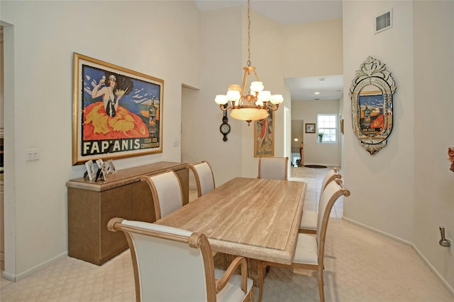 dining space featuring a high ceiling, an inviting chandelier, and light colored carpet