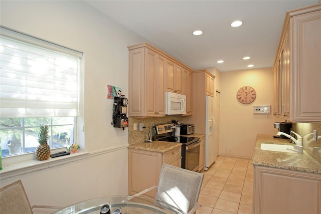 kitchen with white appliances, light stone countertops, light tile patterned floors, tasteful backsplash, and sink