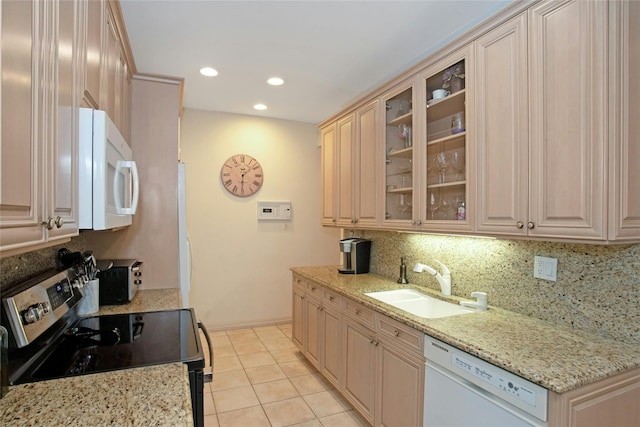 kitchen with white appliances, light stone counters, light tile patterned flooring, and sink