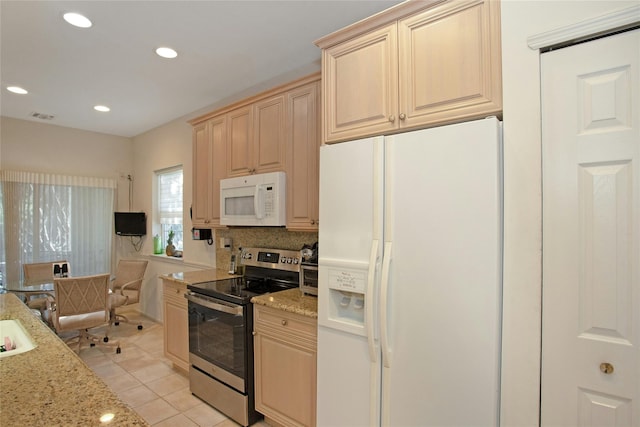 kitchen featuring white appliances, light stone countertops, light brown cabinetry, and light tile patterned floors