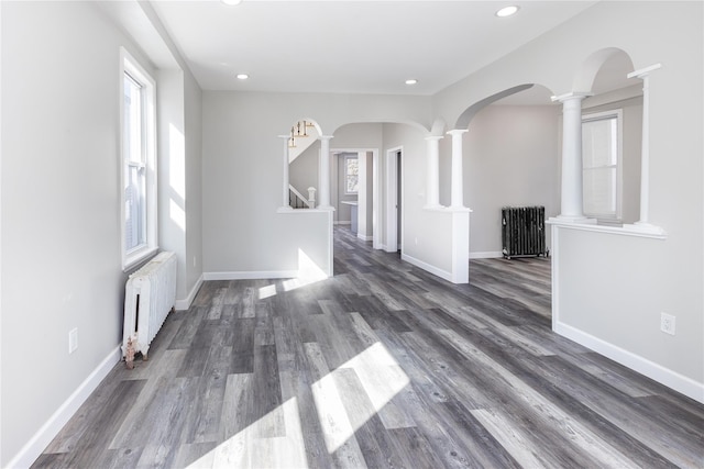 empty room featuring radiator heating unit and dark hardwood / wood-style flooring