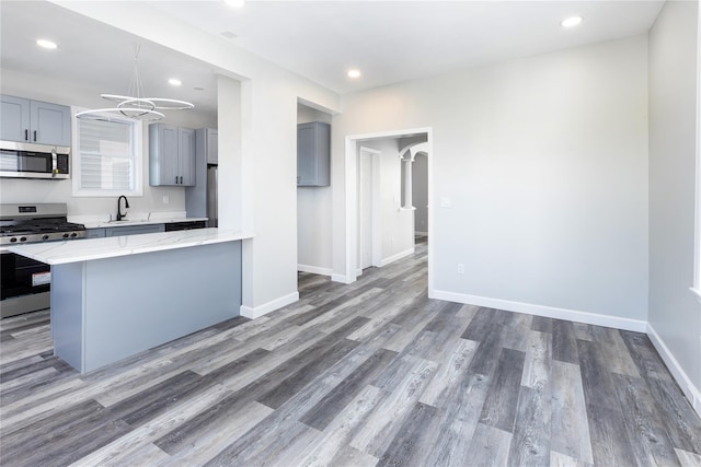 kitchen featuring gray cabinetry, dark hardwood / wood-style floors, sink, and appliances with stainless steel finishes