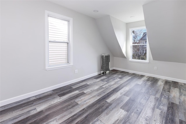 bonus room featuring vaulted ceiling, radiator, and dark hardwood / wood-style floors