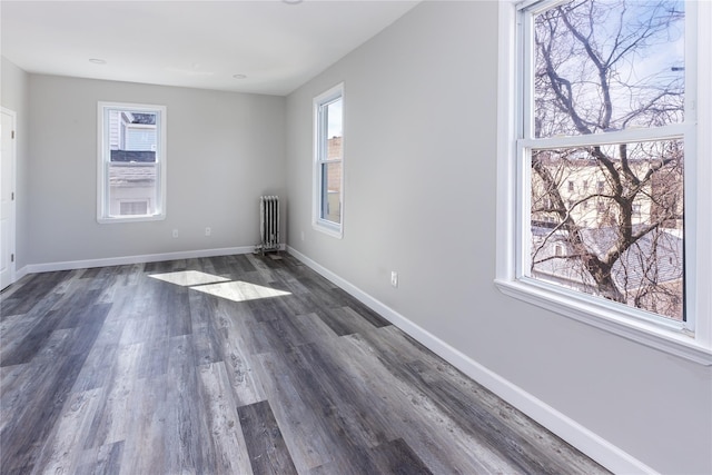 unfurnished room with dark hardwood / wood-style floors and radiator