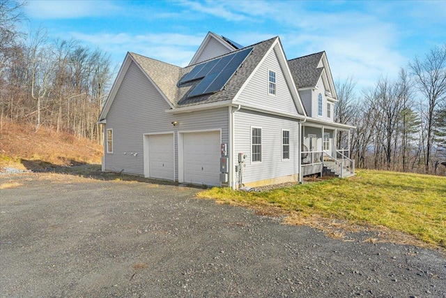 view of side of home featuring solar panels and a garage