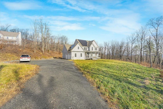 cape cod house with solar panels and a front lawn