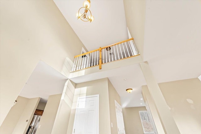 staircase with a towering ceiling and an inviting chandelier