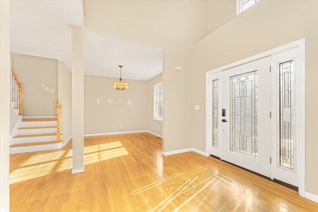 entrance foyer featuring a notable chandelier, wood-type flooring, and plenty of natural light