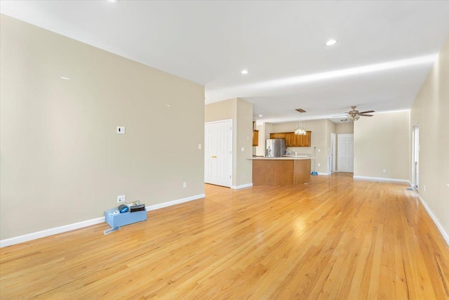 unfurnished living room with ceiling fan and light hardwood / wood-style floors