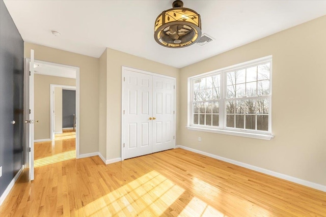 unfurnished bedroom with a closet and light hardwood / wood-style flooring