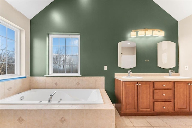 bathroom featuring tile patterned floors, tiled tub, vanity, and lofted ceiling