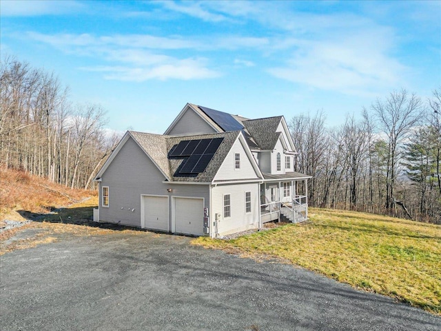 view of home's exterior with a lawn, solar panels, and a garage