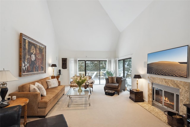 carpeted living room with a fireplace and high vaulted ceiling