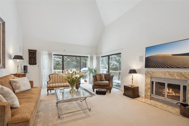 living room with carpet flooring, a premium fireplace, and high vaulted ceiling