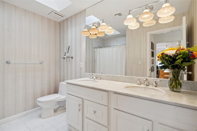 bathroom featuring vanity, a skylight, tile patterned flooring, toilet, and walk in shower