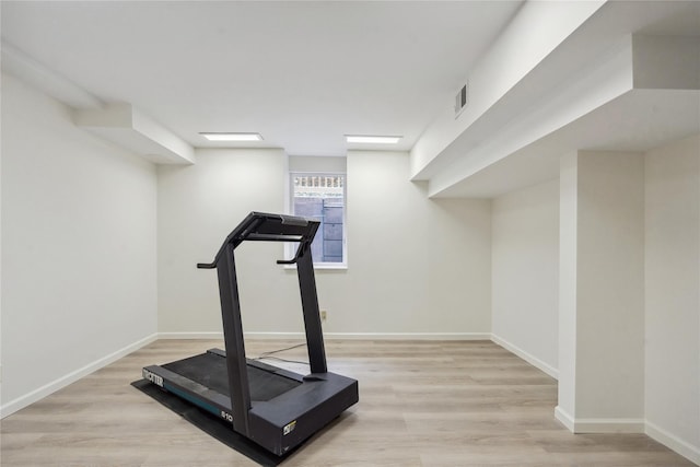 workout area with light hardwood / wood-style flooring