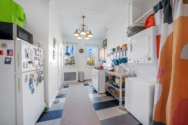 washroom with an inviting chandelier and stacked washer / dryer