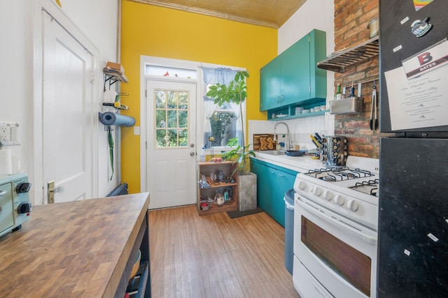 kitchen featuring wooden counters, sink, white gas range oven, ornamental molding, and fridge