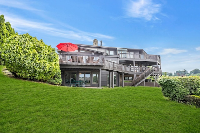 rear view of house featuring a deck and a yard