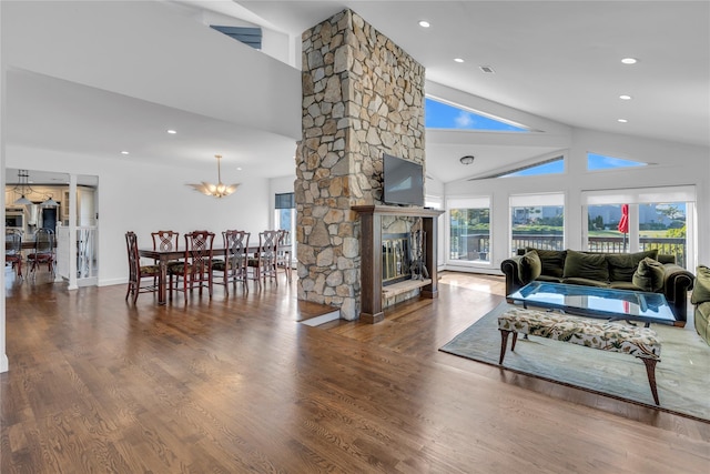 living room featuring a fireplace, high vaulted ceiling, hardwood / wood-style flooring, and an inviting chandelier