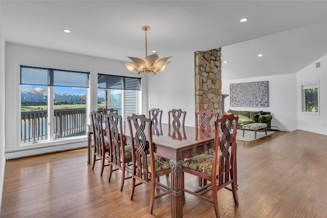 dining space with a notable chandelier, plenty of natural light, hardwood / wood-style floors, and a baseboard heating unit