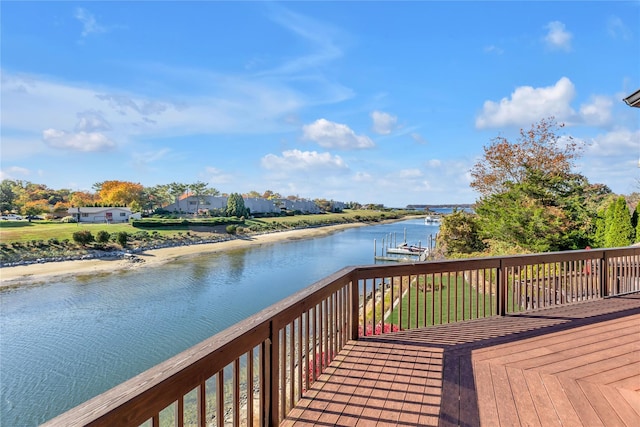 wooden terrace featuring a boat dock and a water view