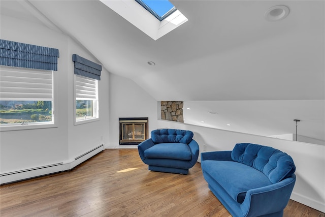 living area featuring wood-type flooring, vaulted ceiling, and a baseboard heating unit