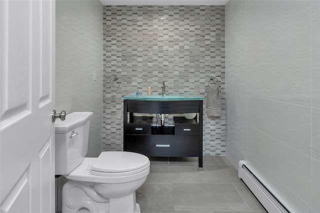 bathroom with tile patterned floors, vanity, a baseboard heating unit, tile walls, and toilet