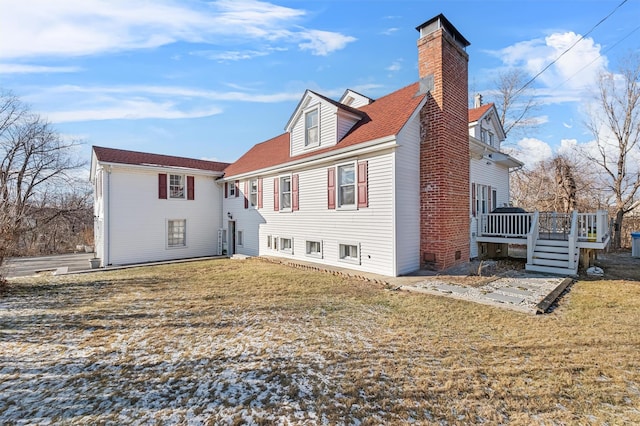 back of property featuring a lawn and a deck