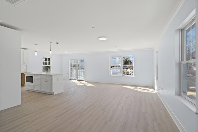 unfurnished living room featuring light wood-type flooring, baseboards, and a wealth of natural light