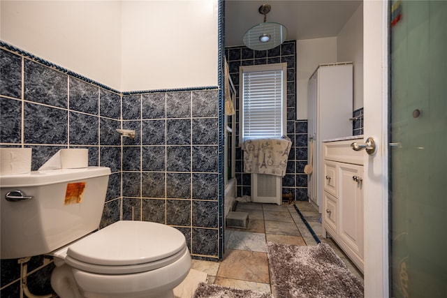 bathroom with vanity, tile walls, and toilet