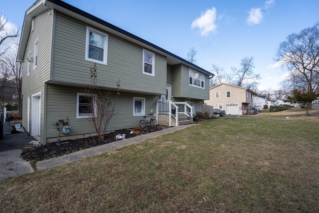 back of property featuring a garage and a yard