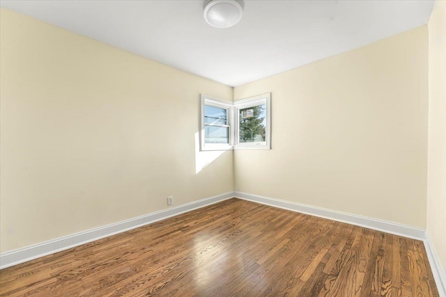 unfurnished room featuring wood finished floors and baseboards