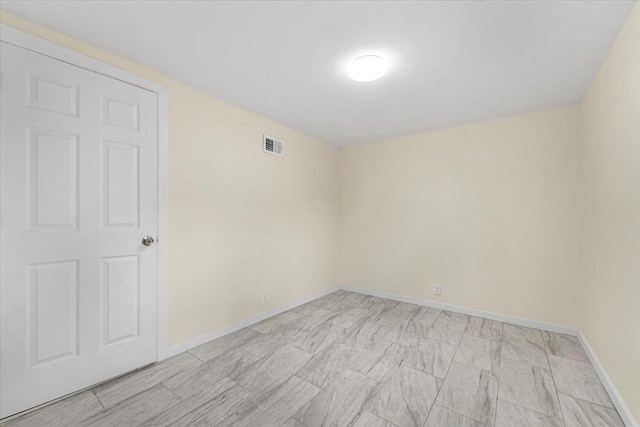 unfurnished room featuring baseboards and visible vents