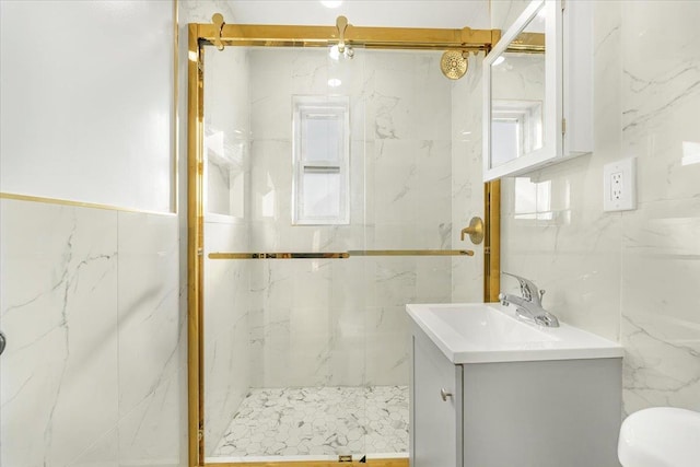 bathroom featuring a shower stall, tile walls, vanity, and toilet