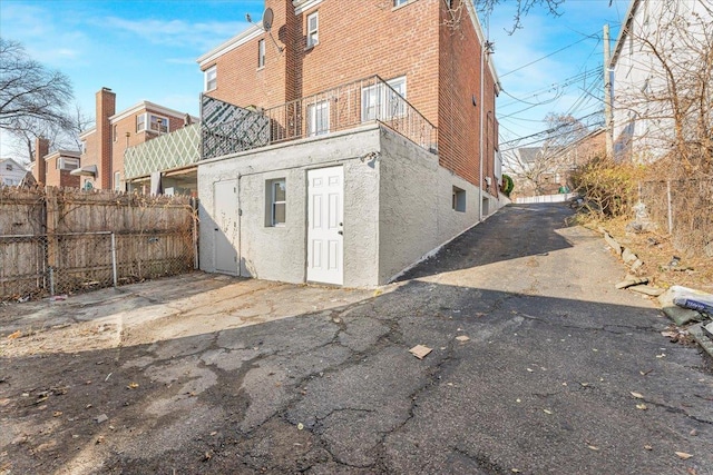 back of property with fence, brick siding, and stucco siding