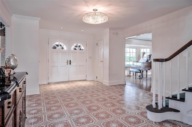 foyer with ornamental molding and a notable chandelier