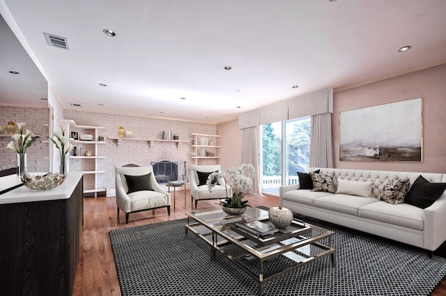 living room featuring dark wood-type flooring, brick wall, and a brick fireplace