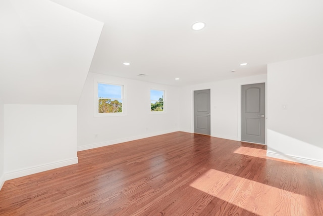 unfurnished room with light hardwood / wood-style floors and vaulted ceiling