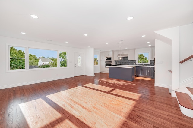 unfurnished living room with light wood-type flooring and sink