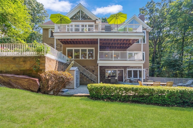 back of house with a balcony, a yard, and a patio area