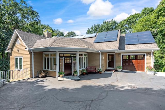 view of front facade featuring a garage and solar panels