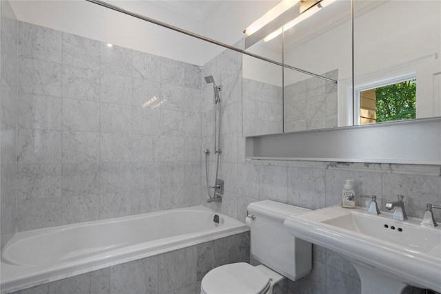 full bathroom with tiled shower / bath, sink, tile walls, and toilet