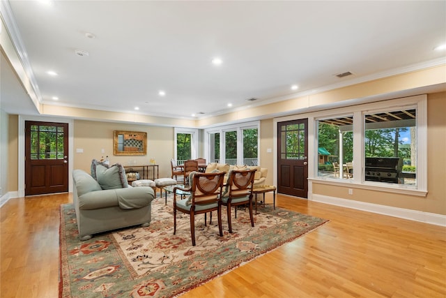 living room with ornamental molding and light hardwood / wood-style flooring